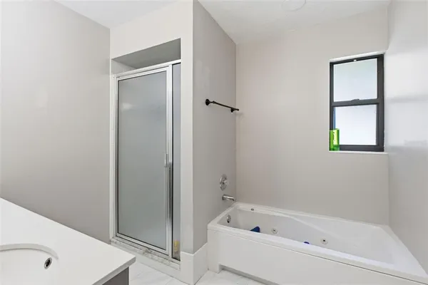 a bathroom with a tub shower and a sink
