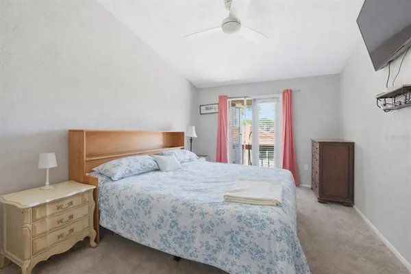 a bedroom with a bed and a flat tv screen on dresser