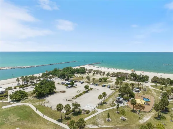 an aerial view of ocean and residential houses with outdoor space