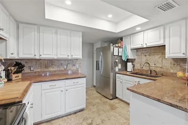 a kitchen with granite countertop a sink stove and refrigerator