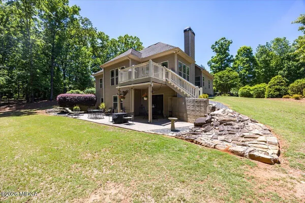 a view of a house with backyard and sitting area