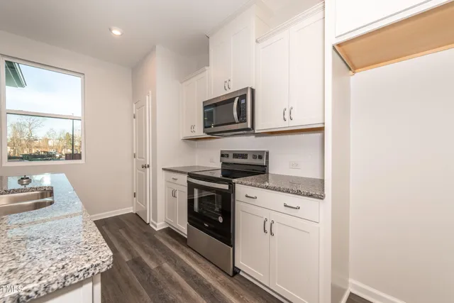 a kitchen with granite countertop cabinets stainless steel appliances and a sink