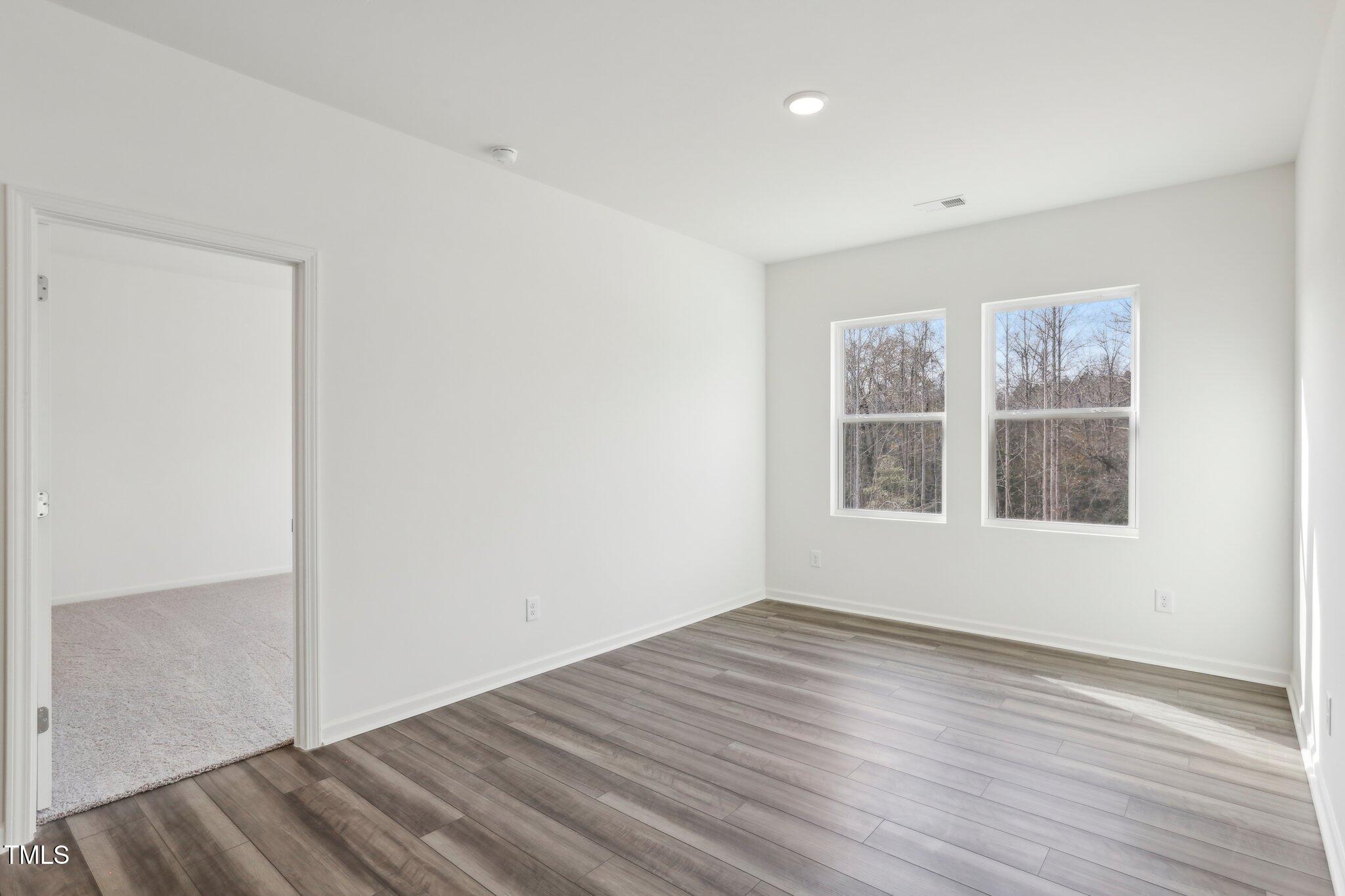 899 Embraer Way Spring Spring Hope, NC 27882 - Photo 7 of 43 a view of an empty room with wooden floor and a window