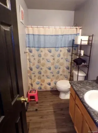 a bathroom with a granite countertop toilet and a sink