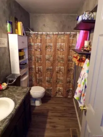 a bathroom with a granite countertop sink toilet and shower