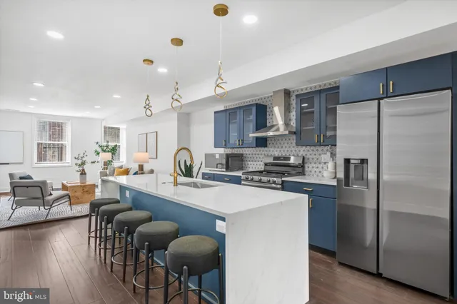 a kitchen with refrigerator a stove a dining table and chairs