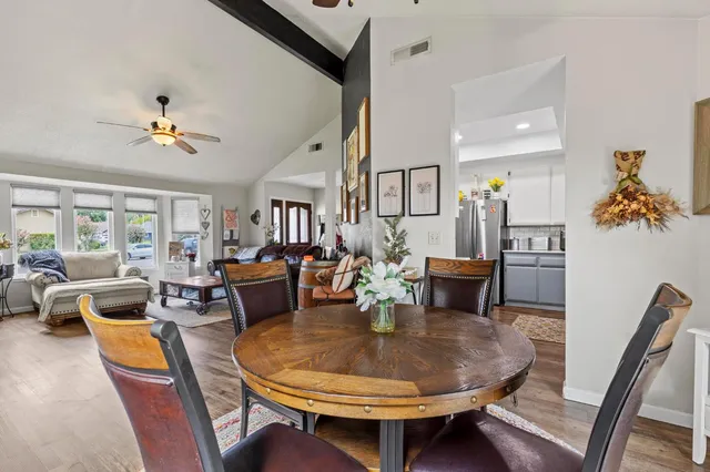 a dining room with furniture a rug a potted plant and a chandelier