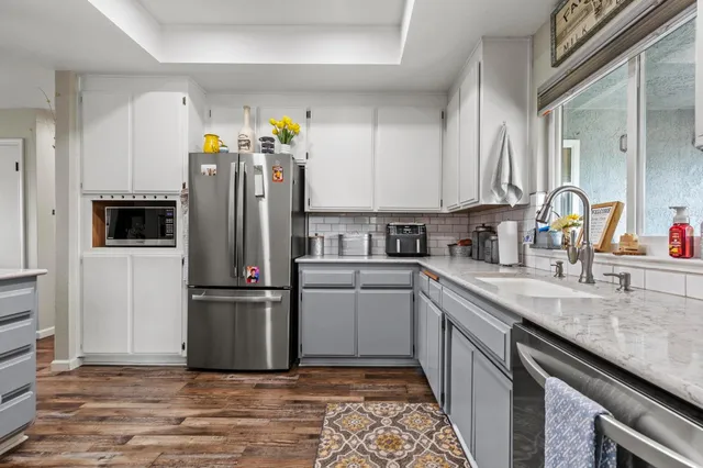a kitchen with granite countertop a refrigerator and a sink