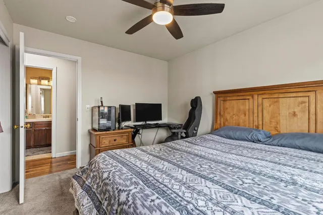 a bedroom with a bed and a flat tv screen on dresser