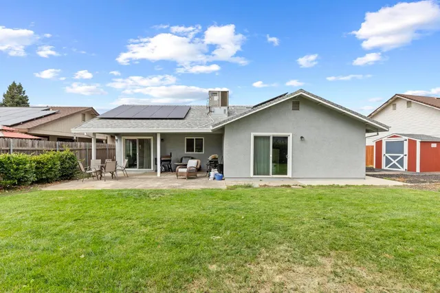 a front view of house with yard barbeque and outdoor seating