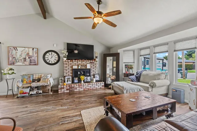 a living room with furniture a clock on wall and a window