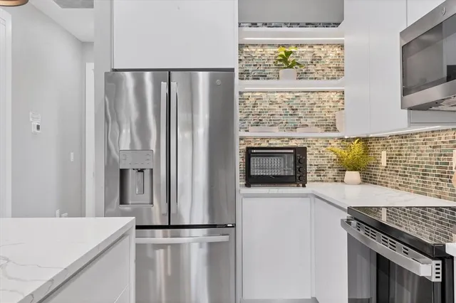 a kitchen with stainless steel appliances a stove microwave and sink