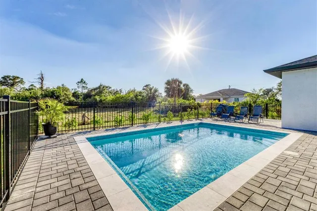 a view of a house with a swimming pool and sitting area