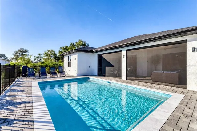 an aerial view of a house with swimming pool and furniture