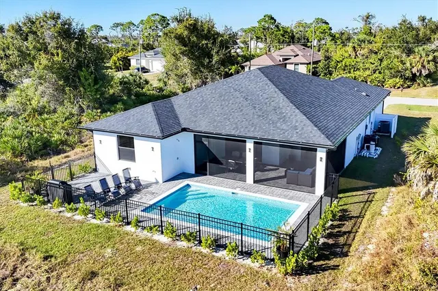 a view of a house with a yard and large trees