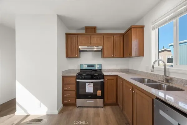 a kitchen with stainless steel appliances granite countertop a sink stove and cabinets