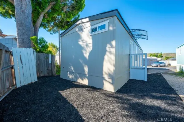a view of a backyard with wooden fence and potted plants
