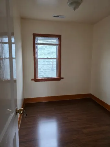 a view of a room with wooden floors and window