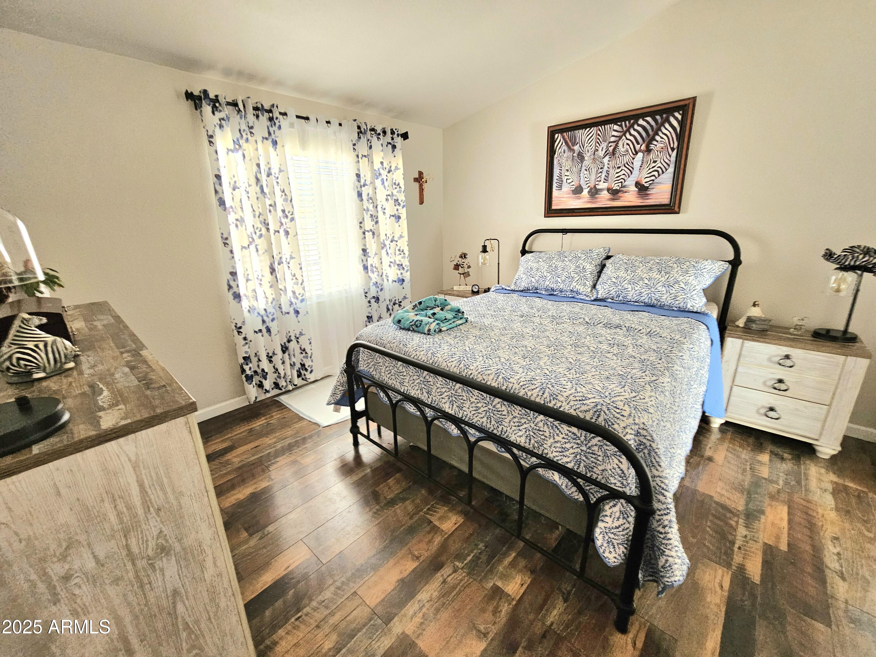 284 North Warren Road Benson, AZ 85602 - Photo 21 of 33 a bedroom with a bed and wooden floor