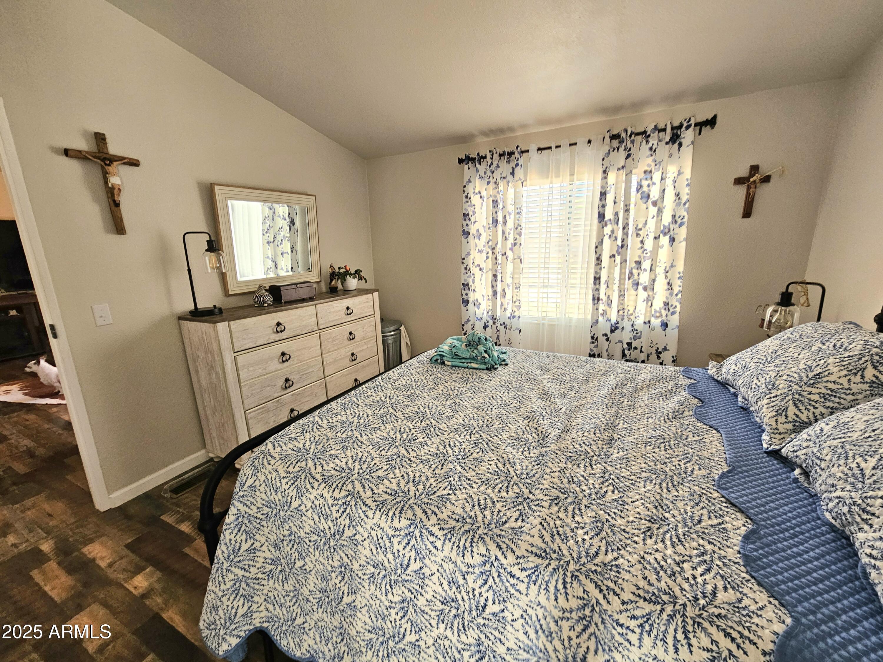 284 North Warren Road Benson, AZ 85602 - Photo 22 of 33 a bedroom with a bed and a chandelier