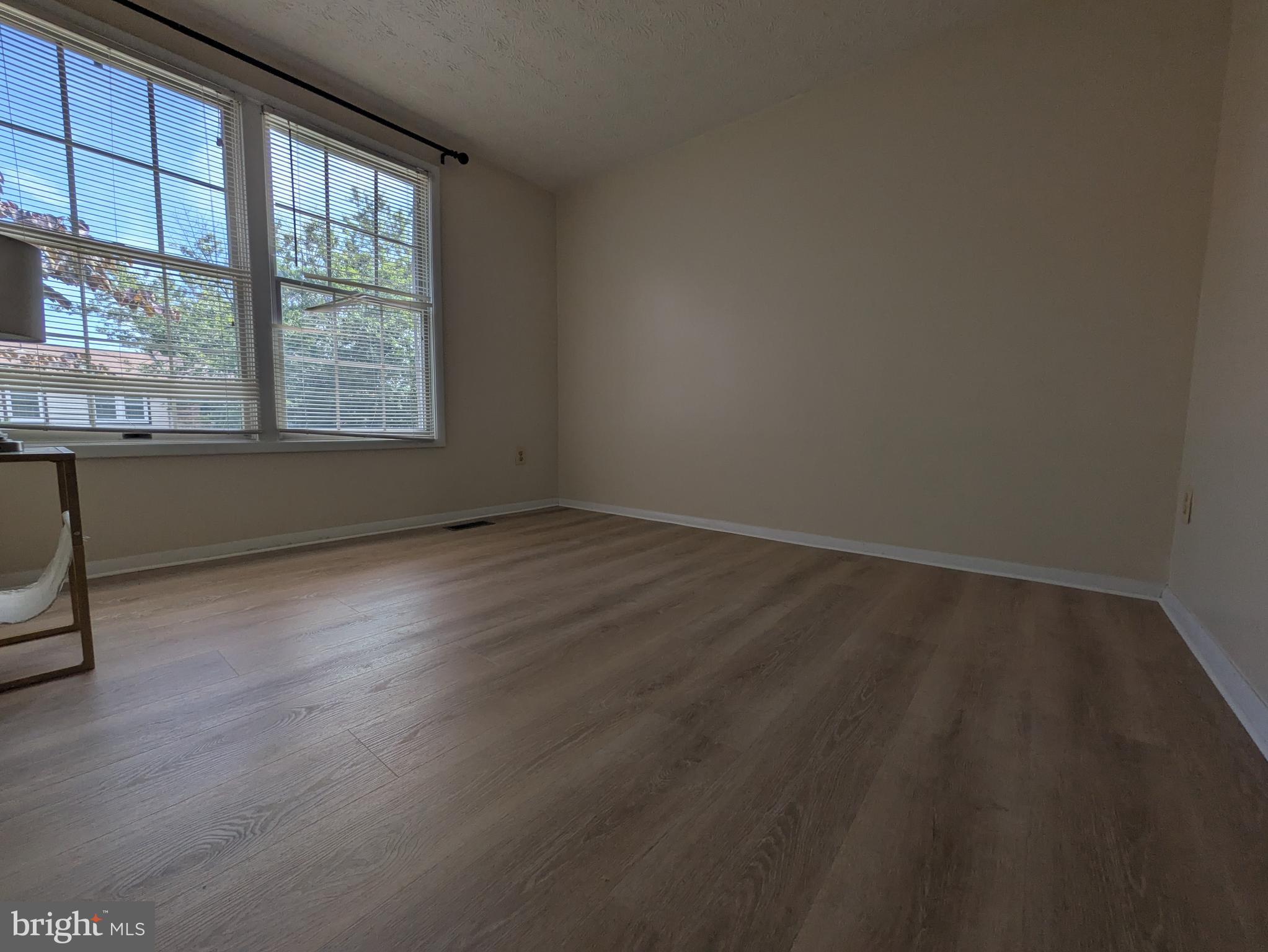 7993 Tyson Oaks Circle Vienna, VA 22182 - Photo 15 of 25 a view of an empty room with wooden floor and a window