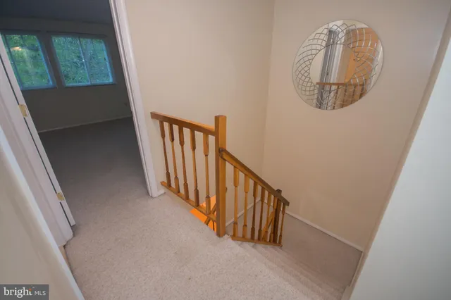 a view of a hallway with wooden floor and a chandelier