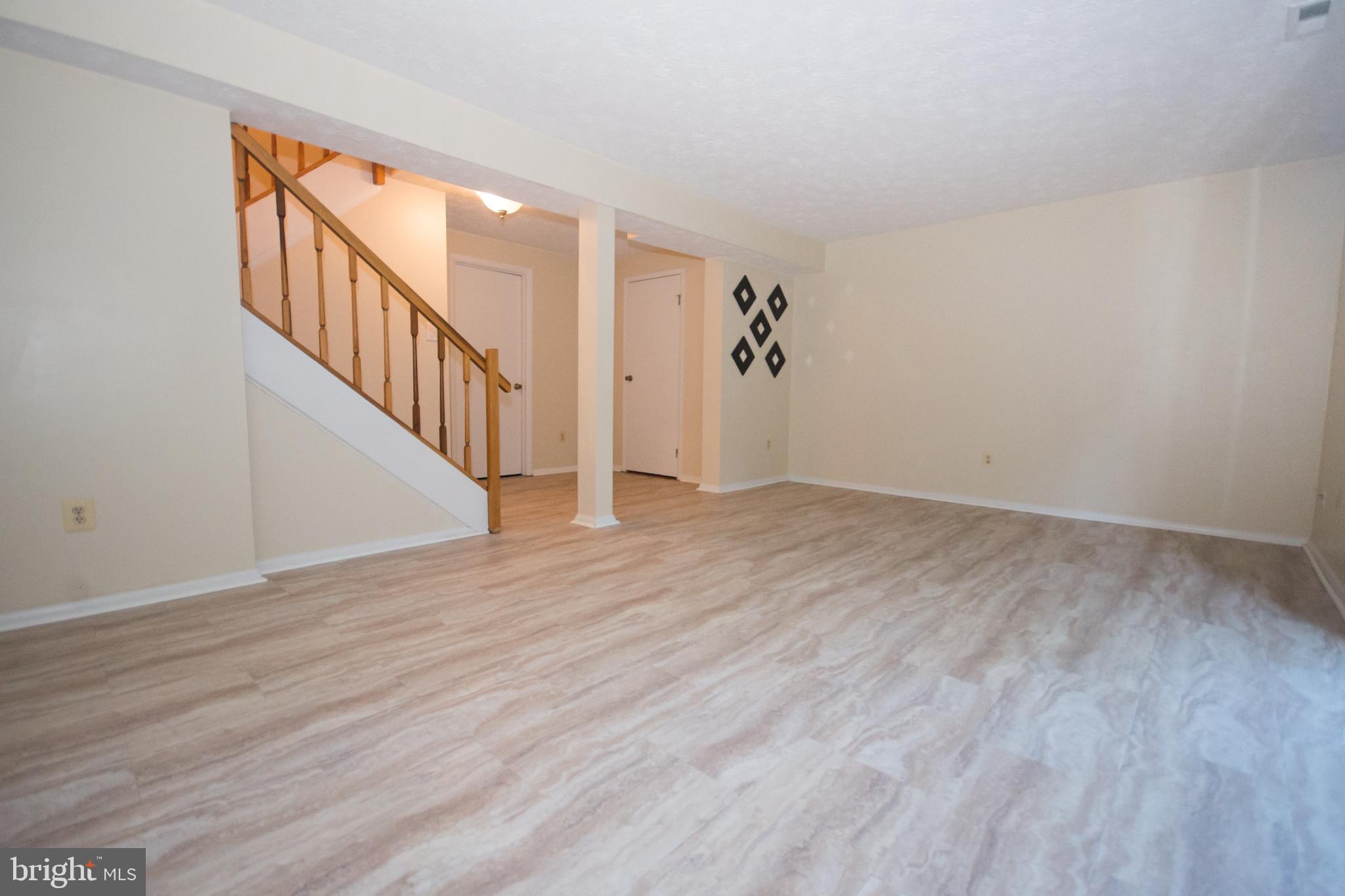 7993 Tyson Oaks Circle Vienna, VA 22182 - Photo 17 of 25 a view of an empty room with wooden floor and stairs