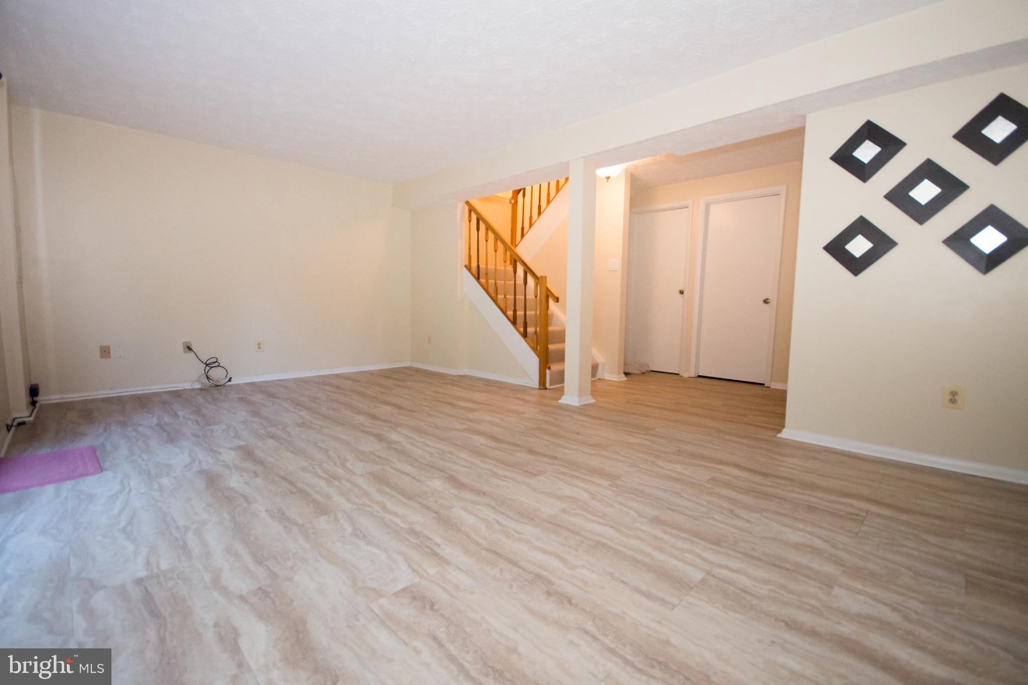 7993 Tyson Oaks Circle Vienna, VA 22182 - Photo 18 of 25 a view of an empty room with wooden floor and stairs