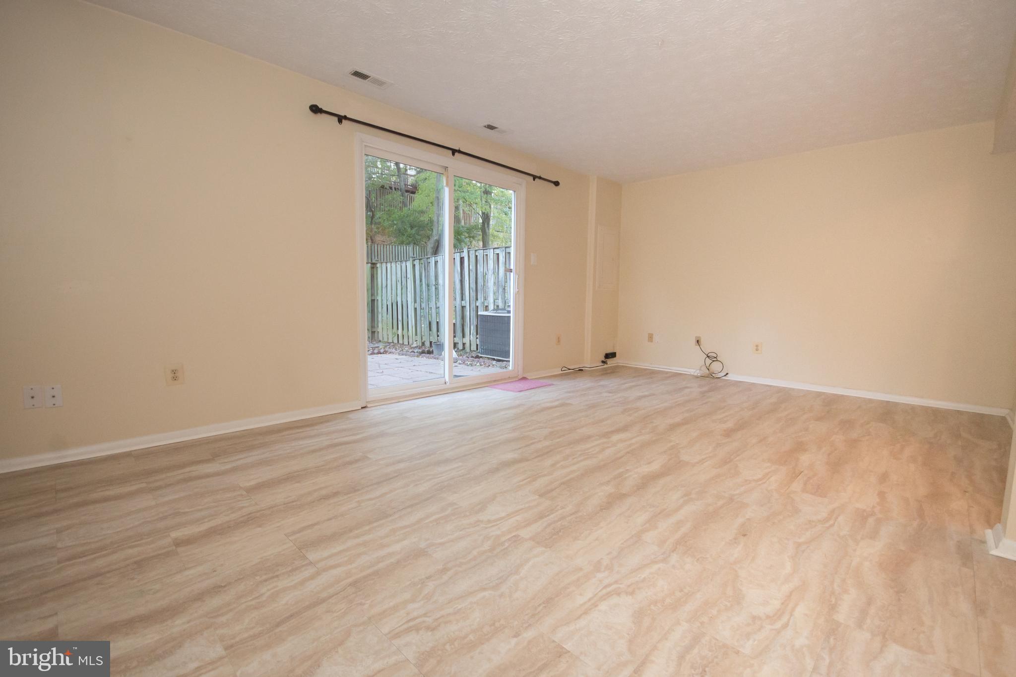 7993 Tyson Oaks Circle Vienna, VA 22182 - Photo 19 of 25 a view of an empty room with wooden floor and a window