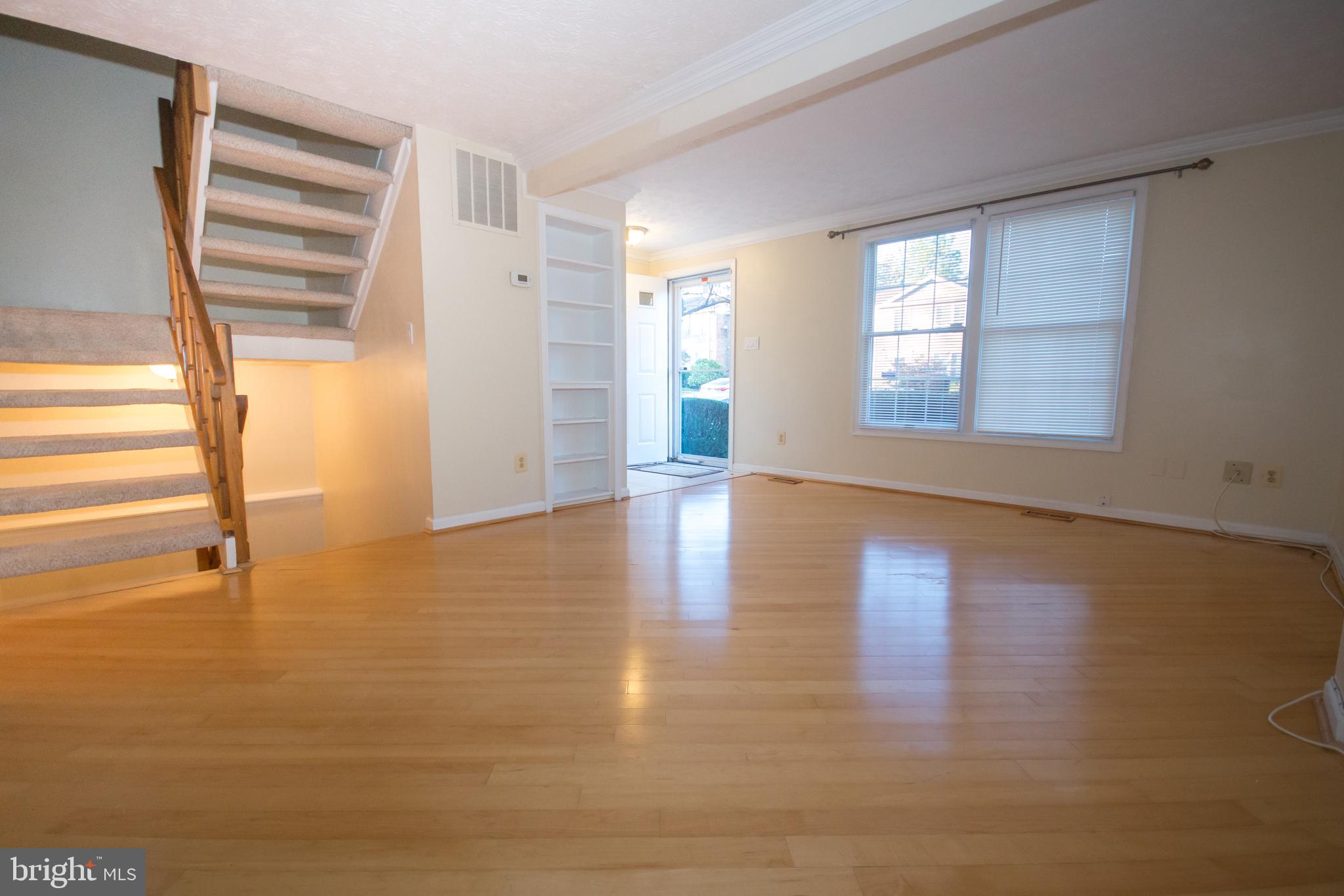 7993 Tyson Oaks Circle Vienna, VA 22182 - Photo 3 of 25 a view of an empty room with wooden floor and a window