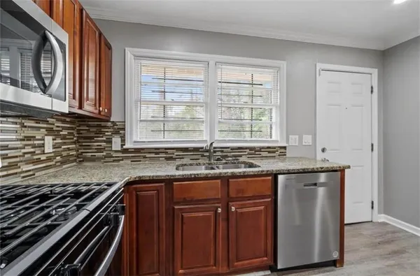 a kitchen with granite countertop a stove and a sink