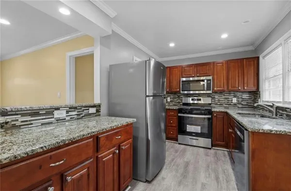 a kitchen with stainless steel appliances granite countertop a stove a sink dishwasher a refrigerator and a oven