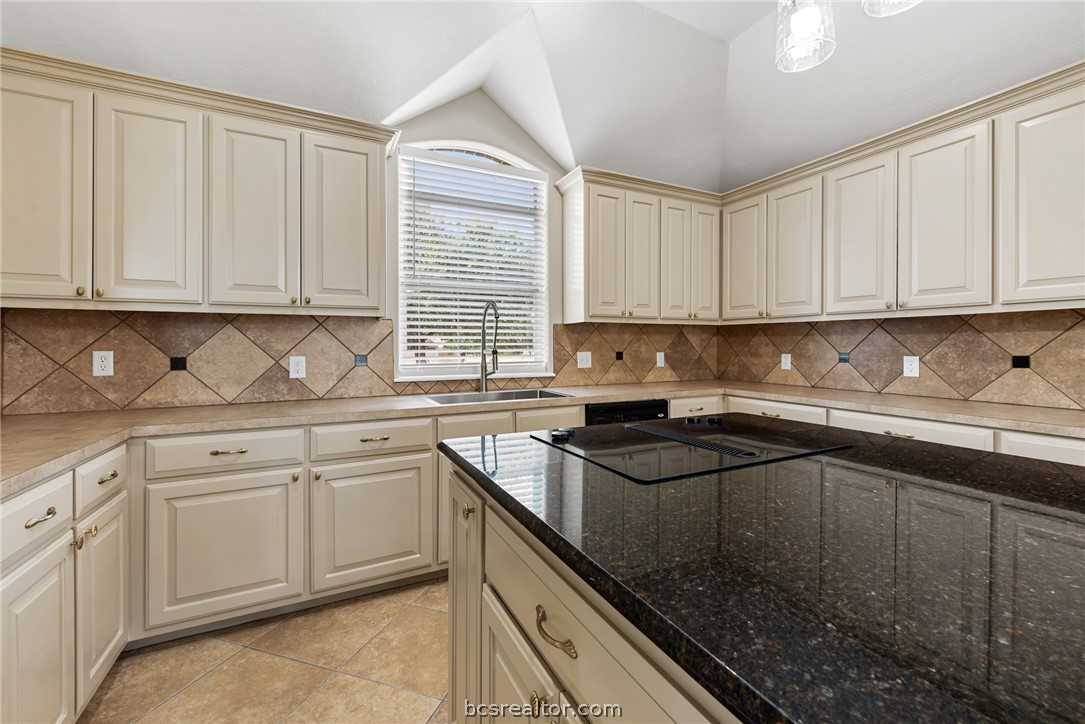 6100 Whitetail Lane Bryan, TX 77808 - Photo 13 of 37 a kitchen with granite countertop a sink stove and cabinets