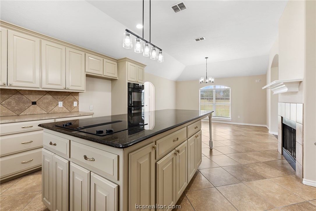 6100 Whitetail Lane Bryan, TX 77808 - Photo 14 of 37 a kitchen with granite countertop a sink a stove and cabinets