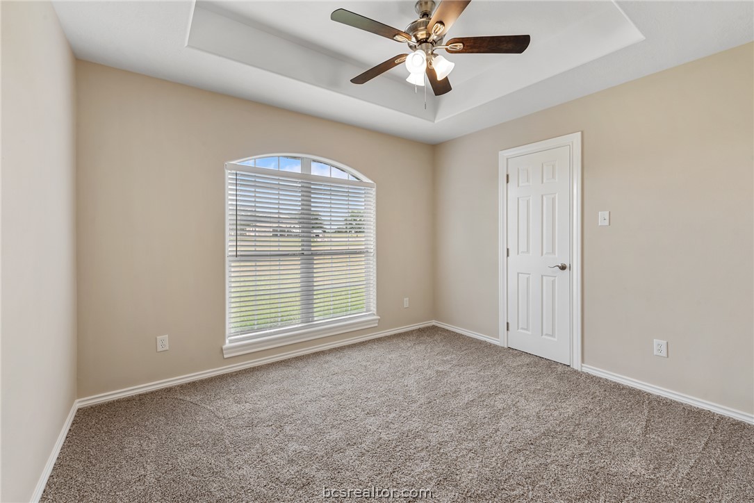 6100 Whitetail Lane Bryan, TX 77808 - Photo 22 of 37 an empty room with chandelier fan and windows