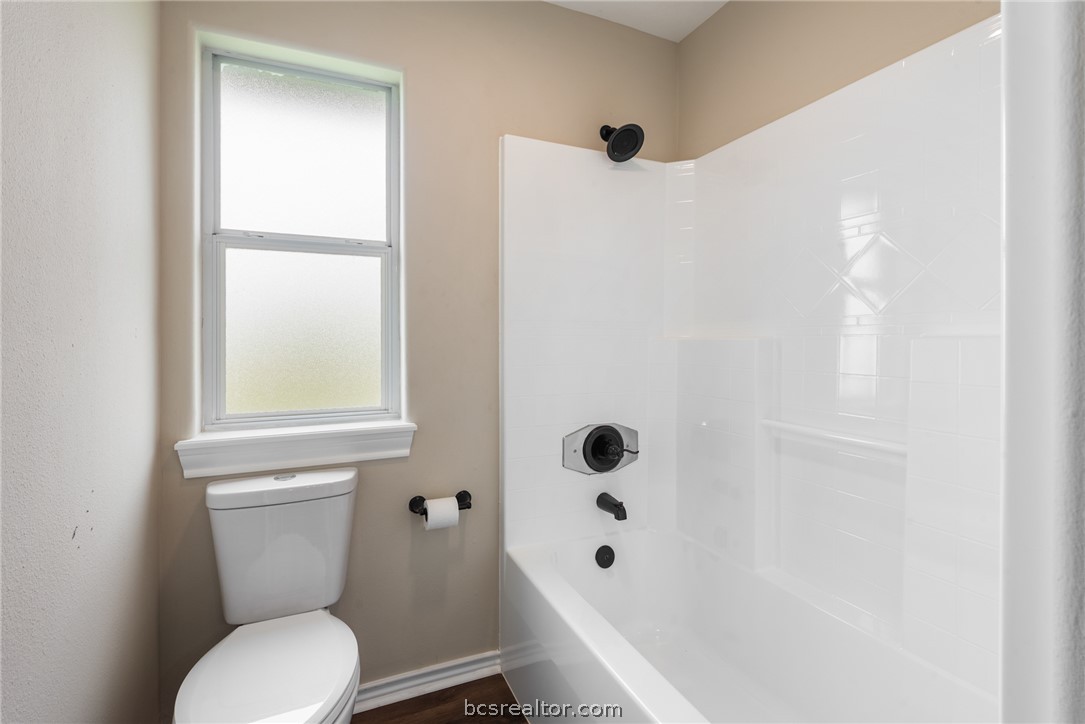 6100 Whitetail Lane Bryan, TX 77808 - Photo 24 of 37 a white toilet sitting next to a bathroom sink