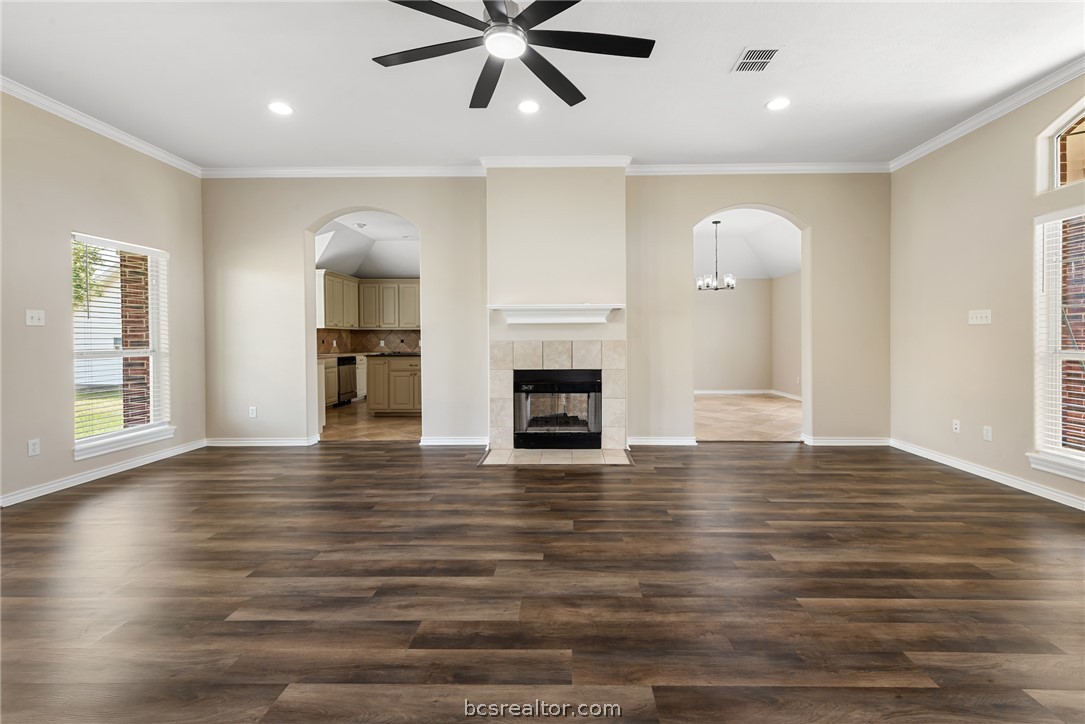 6100 Whitetail Lane Bryan, TX 77808 - Photo 9 of 37 an empty room with wooden floor fireplace and windows