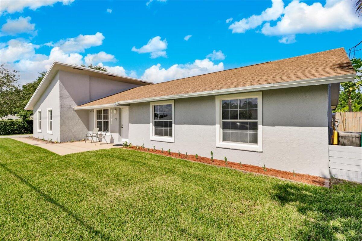 19681 Southeast County Line Road Tequesta, FL 33469 - Photo 2 of 45 a front view of a house with a garden