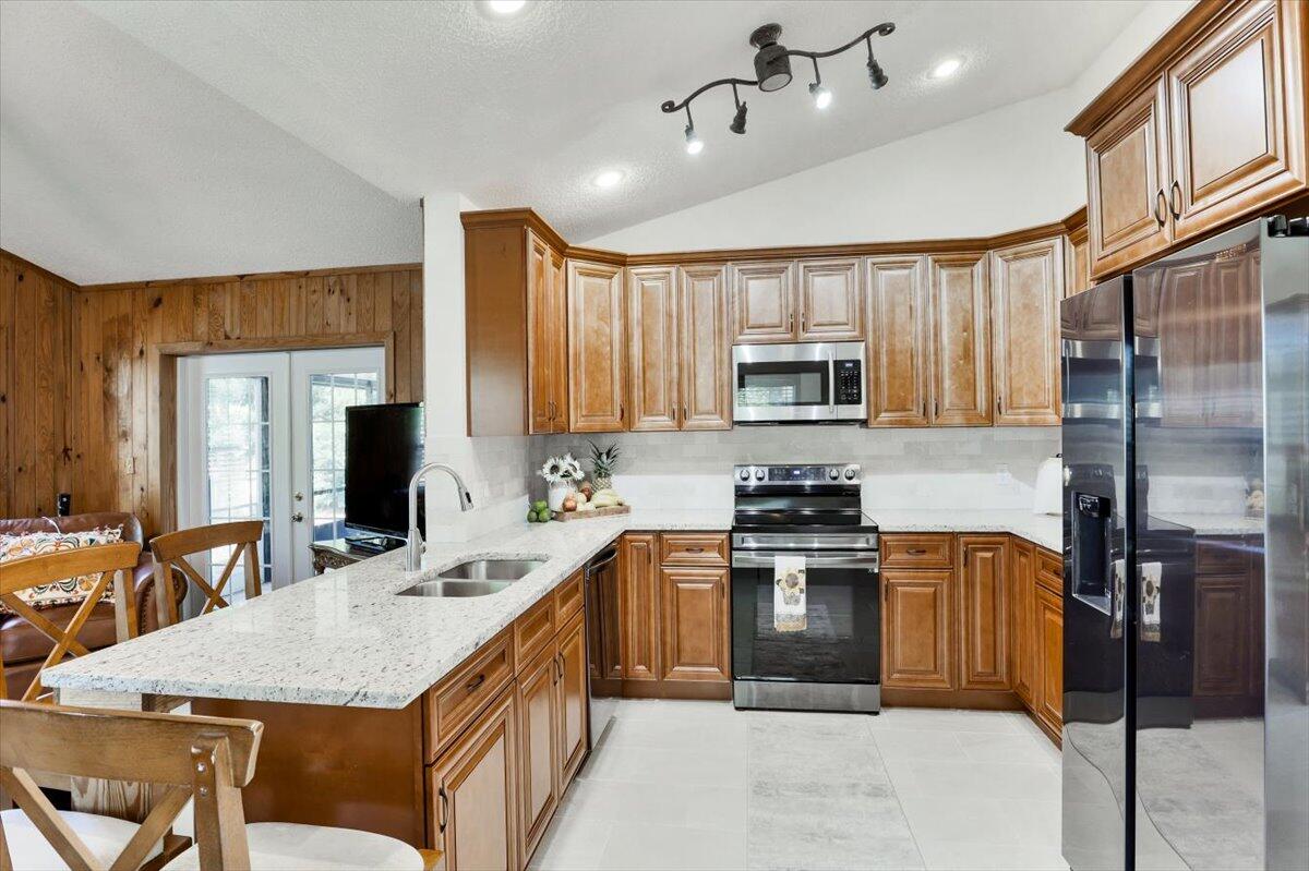 19681 Southeast County Line Road Tequesta, FL 33469 - Photo 11 of 45 a kitchen with kitchen island granite countertop a sink appliances cabinets and furniture