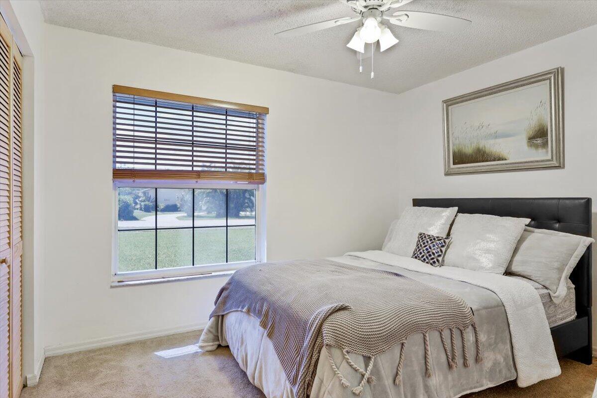 19681 Southeast County Line Road Tequesta, FL 33469 - Photo 17 of 45 a bedroom with a bed and a large window