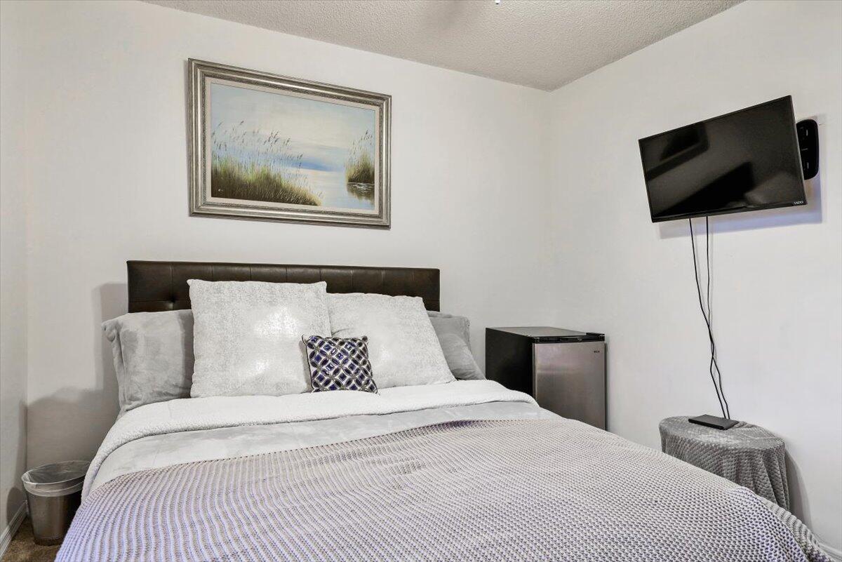 19681 Southeast County Line Road Tequesta, FL 33469 - Photo 18 of 45 a bedroom with a bed and a flat screen tv