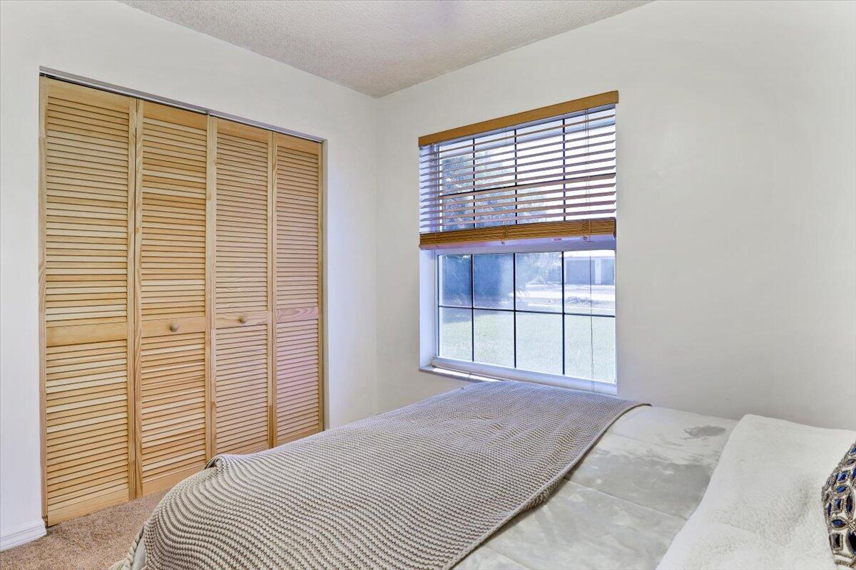 19681 Southeast County Line Road Tequesta, FL 33469 - Photo 19 of 45 a bedroom with a bed and a window