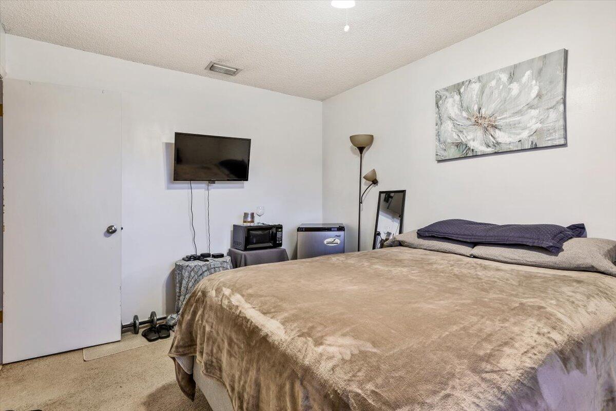 19681 Southeast County Line Road Tequesta, FL 33469 - Photo 21 of 45 a bedroom with a bed and a flat screen tv