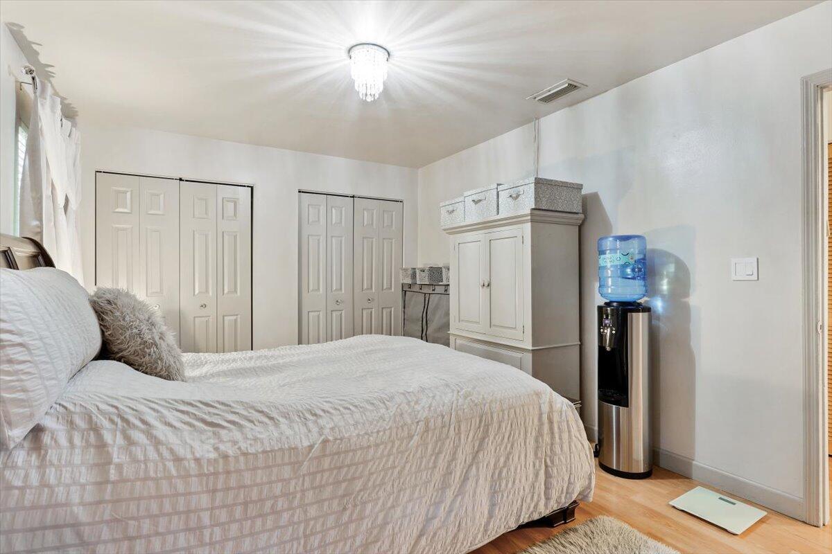 19681 Southeast County Line Road Tequesta, FL 33469 - Photo 25 of 45 a bedroom with a large bed and a chandelier