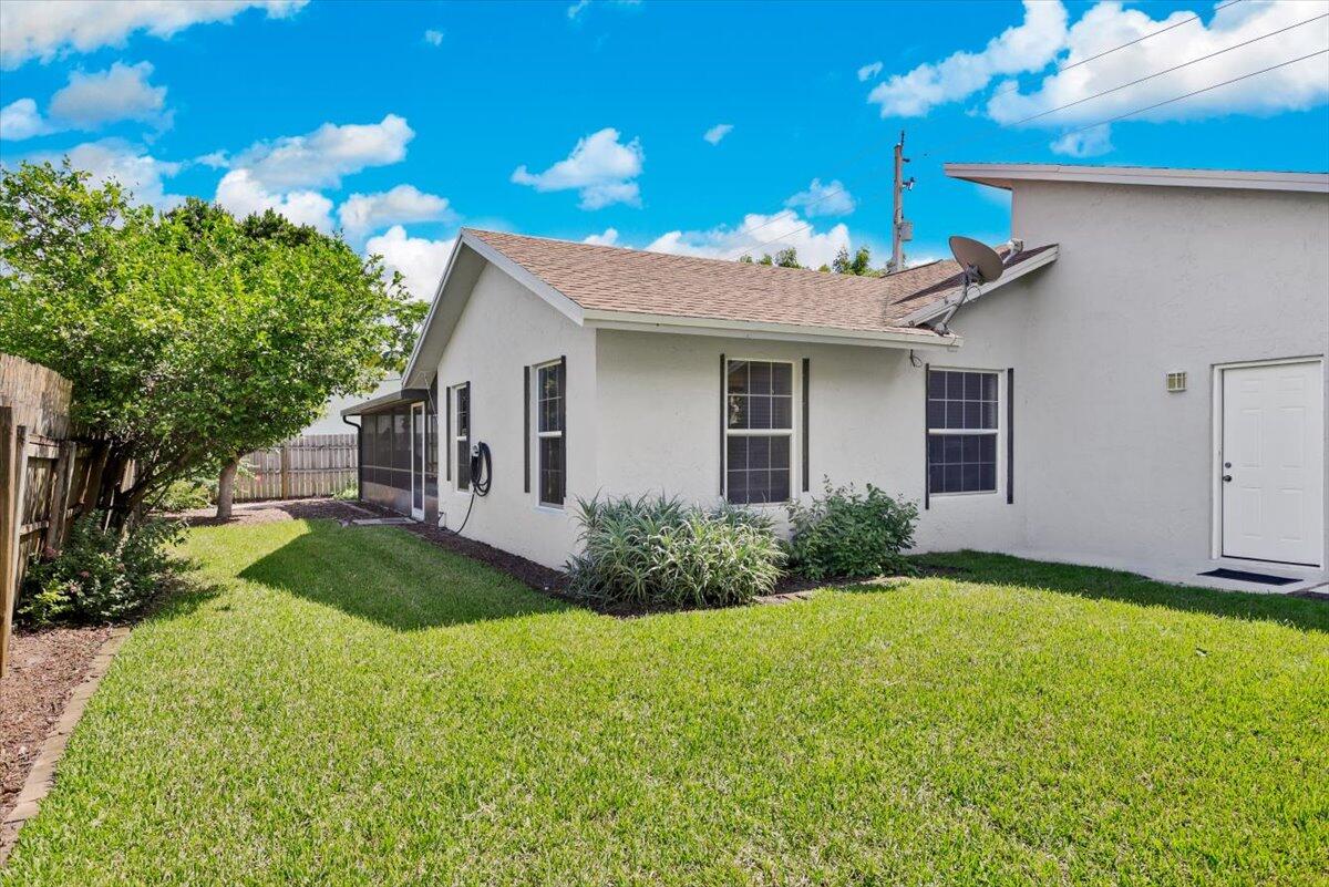 19681 Southeast County Line Road Tequesta, FL 33469 - Photo 28 of 45 a view of a house with brick walls and a yard