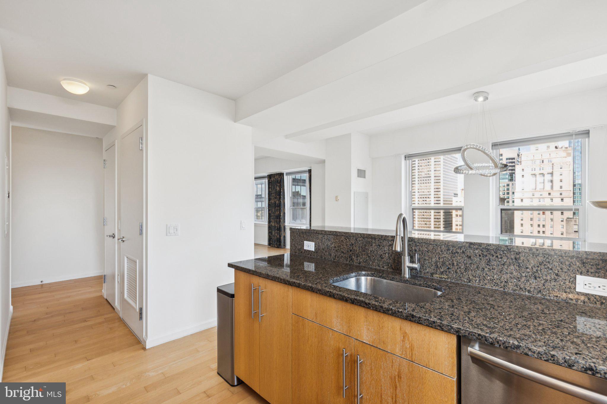 1425 Locust Street, Unit 21A Philadelphia, PA 19102 - Photo 2 of 8 a kitchen with granite countertop a sink and a window