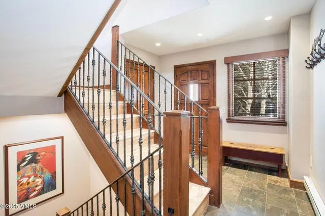 a view of staircase with wooden floor and a rug