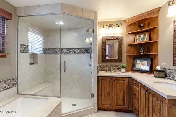 a bathroom with a tub shower vanity and a sink