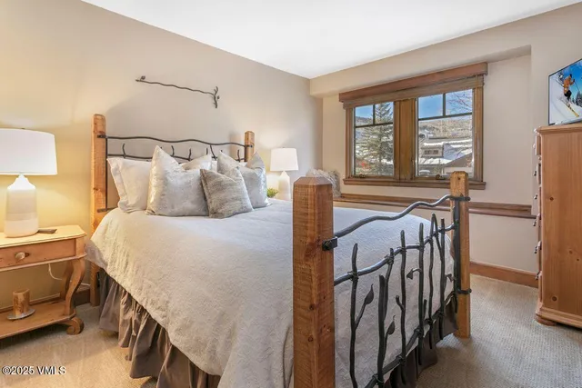 a bedroom with a bed and a large window