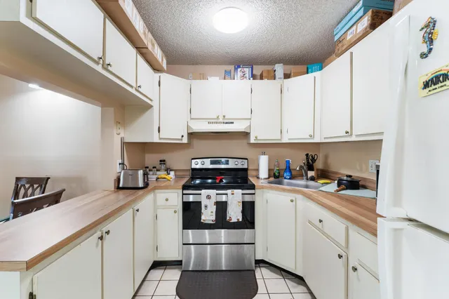 a kitchen with stainless steel appliances granite countertop a stove and white cabinets